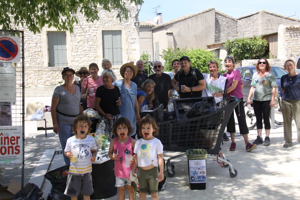 Les équipes sur la place du village autour des déchets collectés, caddie compris